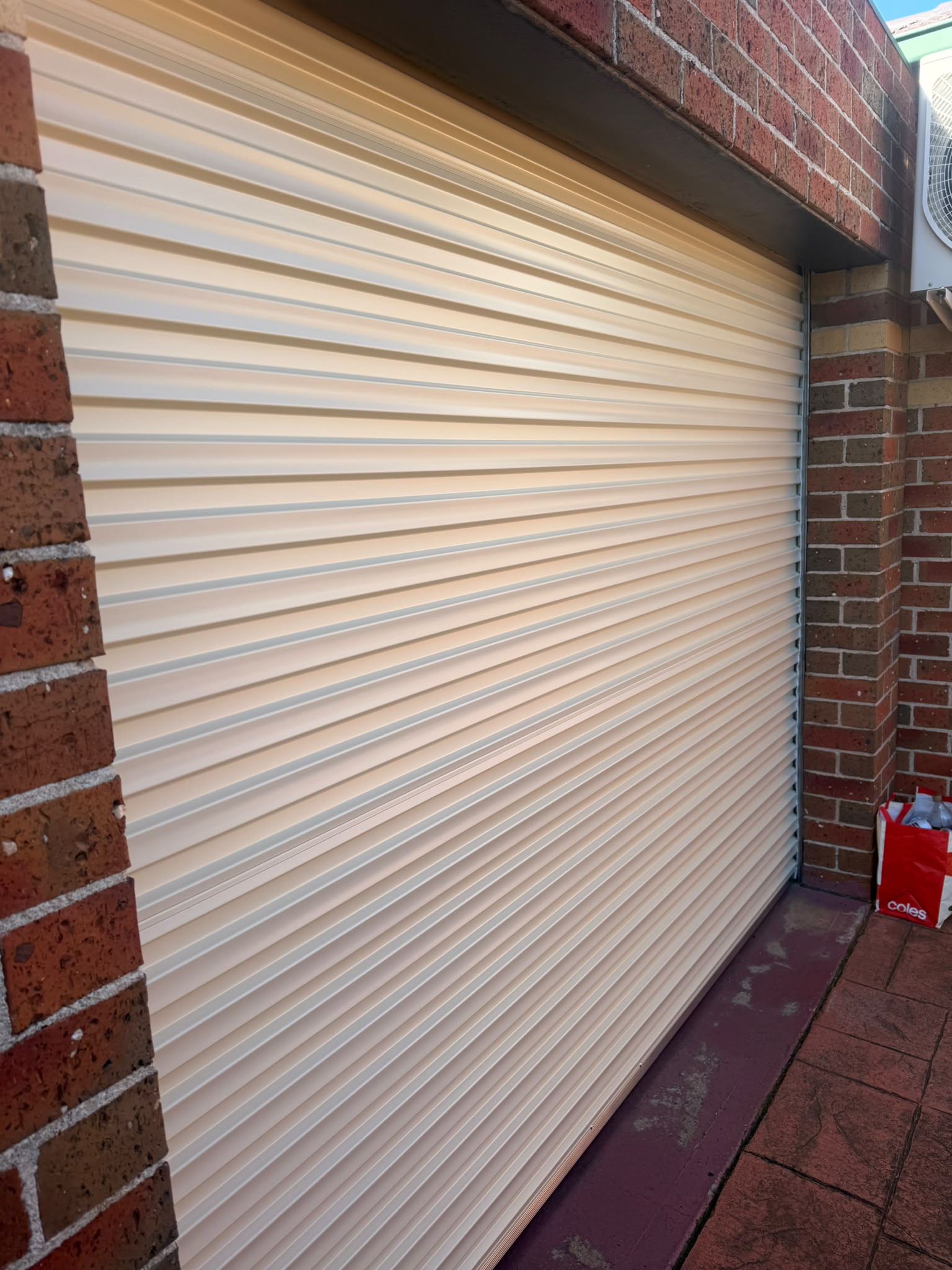 Side view of the new garage door showing the guide track and curtain alignment